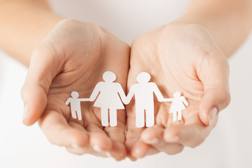 close up of womans cupped hands showing paper man family