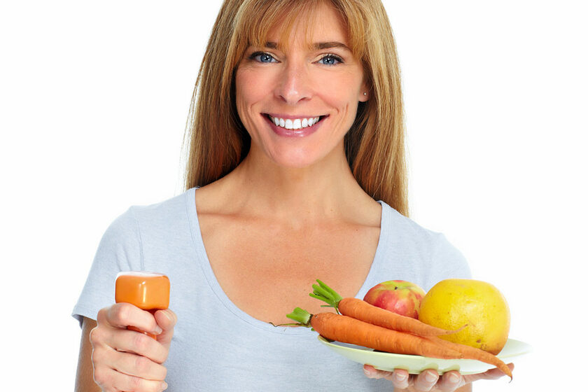 Healthy woman with dumbbell and fruits.