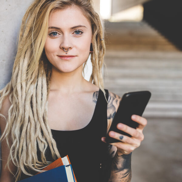 young tattooed women texting message on mobile phone